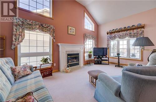 Living room featuring light carpet, a high ceiling, and a gas fireplace - 42 River Run Road, Drayton, ON - Indoor Photo Showing Living Room With Fireplace