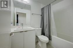 Full bathroom with tile patterned flooring, vanity, toilet, and shower / bathtub combination with curtain - 