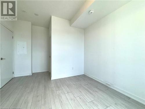 Spare room featuring light wood-type flooring and electric panel - 55 Duke Street W Unit# 1210, Kitchener, ON - Indoor Photo Showing Other Room