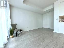 Empty room with light wood-type flooring and a raised ceiling - 