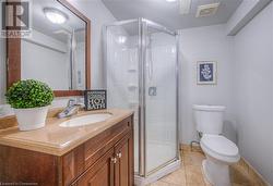 Bathroom with tile patterned floors, vanity, toilet, and walk in shower - 