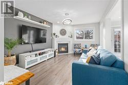 Living room with a fireplace, a textured ceiling, and light wood-type flooring - 