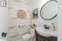 Bathroom featuring wooden walls, vanity, and toilet - 