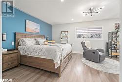 Bedroom with a chandelier, light hardwood / wood-style floors, and a textured ceiling - 