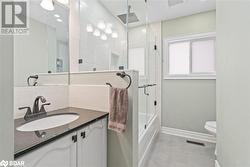 Full bathroom with vanity, toilet, and shower / bath combination with glass door - 