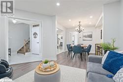 Living room featuring a notable chandelier and light wood-type flooring - 