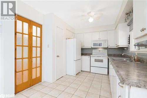 Kitchen with white cabinetry, french doors, sink, tasteful backsplash, and white appliances - 15 Oakington Place, Mississauga, ON - Indoor Photo Showing Kitchen With Double Sink