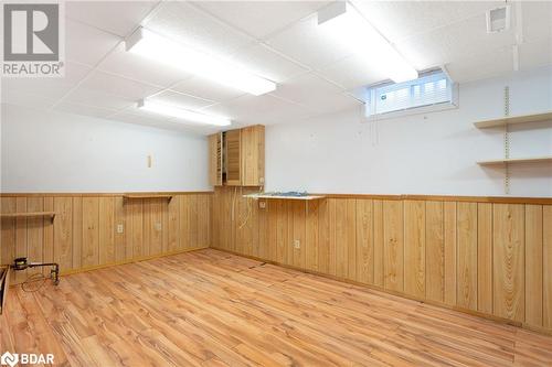 Empty room with a drop ceiling, wooden walls, and light hardwood / wood-style flooring - 15 Oakington Place, Mississauga, ON - Indoor