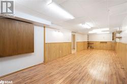 Basement with a paneled ceiling and light hardwood / wood-style flooring - 