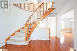 Stairs featuring hardwood / wood-style flooring and an inviting chandelier - 