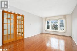 Empty room with light wood-type flooring and french doors - 