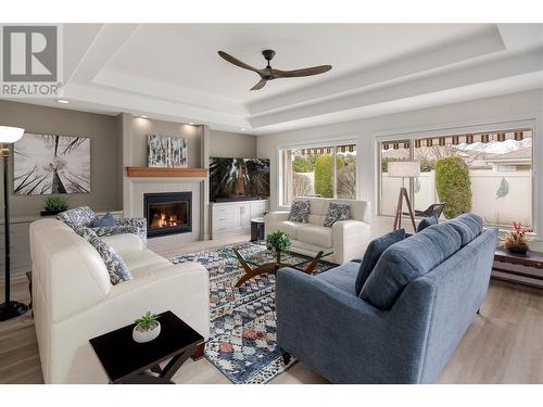 Designer ceiling fan, fireplace surround refinished and gas unit cleaned, custom cabinets, custom power operated window blinds - 2365 Stillingfleet Road Unit# 360, Kelowna, BC - Indoor Photo Showing Living Room With Fireplace