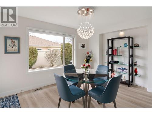 . Designer crystal chandelier, custom power operated window blinds - 2365 Stillingfleet Road Unit# 360, Kelowna, BC - Indoor Photo Showing Dining Room