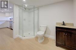 Bathroom featuring toilet, hardwood / wood-style floors, vanity, and walk in shower - 