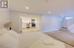 Bedroom featuring light hardwood / wood-style floors and white refrigerator - 