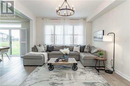 Living room with wood-type flooring and a notable chandelier - 116 Whithorn Crescent, Caledonia, ON - Indoor Photo Showing Living Room