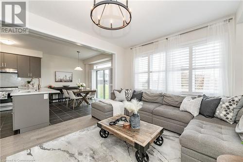 Living room featuring light hardwood / wood-style floors, an inviting chandelier, and sink - 116 Whithorn Crescent, Caledonia, ON - Indoor Photo Showing Living Room