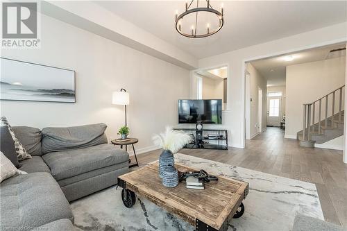 Living room with hardwood / wood-style floors and an inviting chandelier - 116 Whithorn Crescent, Caledonia, ON - Indoor Photo Showing Living Room