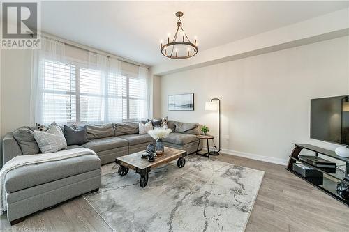 Living room featuring a healthy amount of sunlight, a chandelier, and wood-type flooring - 116 Whithorn Crescent, Caledonia, ON - Indoor Photo Showing Living Room