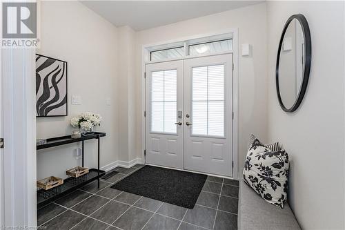 Foyer entrance with dark tile patterned floors - 116 Whithorn Crescent, Caledonia, ON - Indoor Photo Showing Other Room