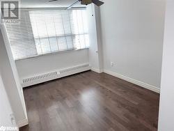 Unfurnished room featuring a baseboard radiator, ceiling fan, and dark wood-type flooring - 