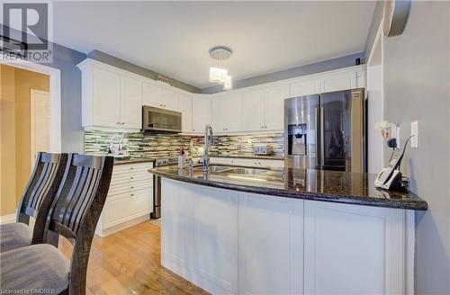 Kitchen featuring white cabinets, light wood-type flooring, appliances with stainless steel finishes, and sink - 32 Triller Avenue, Cambridge, ON - Indoor Photo Showing Kitchen With Upgraded Kitchen