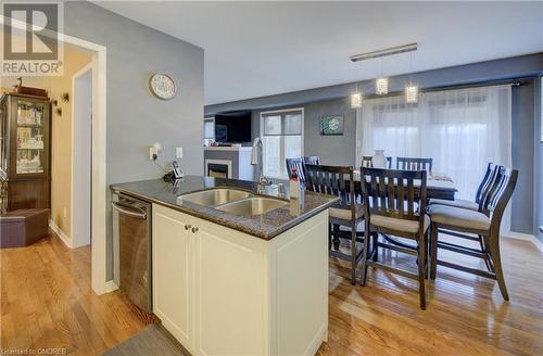 Kitchen with white cabinetry, light wood-type flooring, pendant lighting, sink, and dishwasher - 32 Triller Avenue, Cambridge, ON - Indoor Photo Showing Other Room