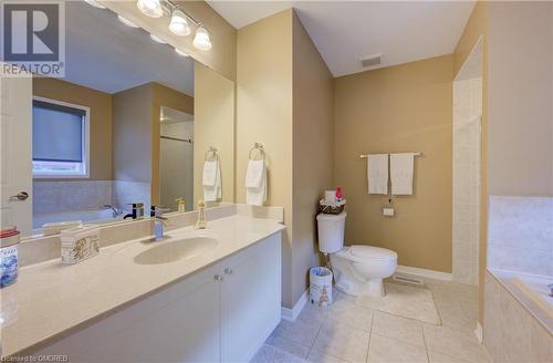 Bathroom featuring toilet, vanity, a relaxing tiled tub, and tile patterned floors - 32 Triller Avenue, Cambridge, ON - Indoor Photo Showing Bathroom