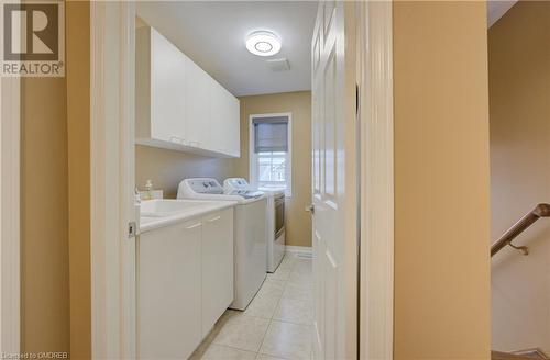 Washroom with separate washer and dryer, cabinets, and light tile patterned floors - 32 Triller Avenue, Cambridge, ON - Indoor Photo Showing Laundry Room