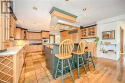 Kitchen with a kitchen bar, stainless steel oven, a textured ceiling, sink, and a center island - 