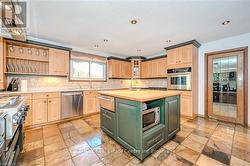 Kitchen with decorative backsplash, a kitchen island with sink, appliances with stainless steel finishes, and wood counters - 