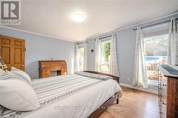 Bedroom featuring light hardwood / wood-style flooring and multiple windows - 