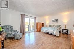 Bedroom with hardwood / wood-style flooring, crown molding, and access to outside - 