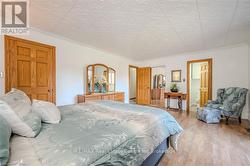 Bedroom with wood-type flooring, crown molding, and ensuite bath - 