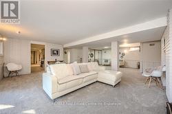 Living room featuring decorative columns, carpet, and brick wall - 