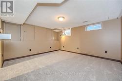 Basement featuring a textured ceiling and light carpet - 