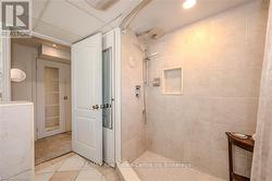 Bathroom with tile patterned flooring, a tile shower, and a drop ceiling - 