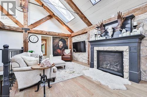 Living room with beamed ceiling, a stone fireplace, light wood-type flooring, and high vaulted ceiling - 1486 Kenmuir Avenue, Mississauga, ON - Indoor Photo Showing Living Room With Fireplace