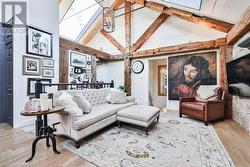 Living room with hardwood / wood-style floors, beamed ceiling, high vaulted ceiling, and a chandelier - 