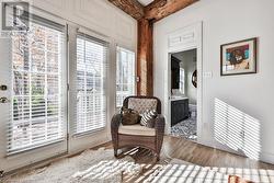 Sitting room with beamed ceiling, light hardwood / wood-style floors, and a wealth of natural light - 