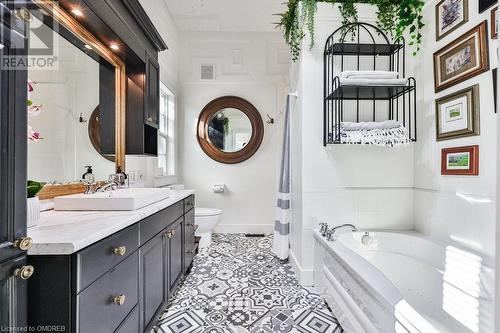 Bathroom with tiled bath, tile patterned flooring, vanity, and toilet - 1486 Kenmuir Avenue, Mississauga, ON - Indoor Photo Showing Bathroom