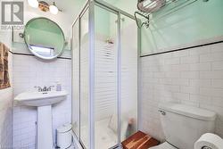 Bathroom with walk in shower, toilet, and tile walls - 