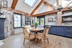 Dining space with high vaulted ceiling, light hardwood / wood-style floors, and a wealth of natural light - 