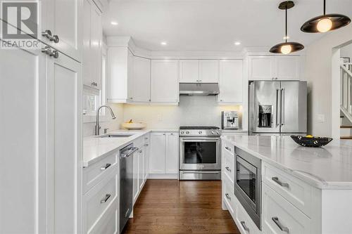 Microwave in island bar, quartz countertops throughout - 432 Strathcona Mews Sw, Calgary, AB - Indoor Photo Showing Kitchen With Upgraded Kitchen