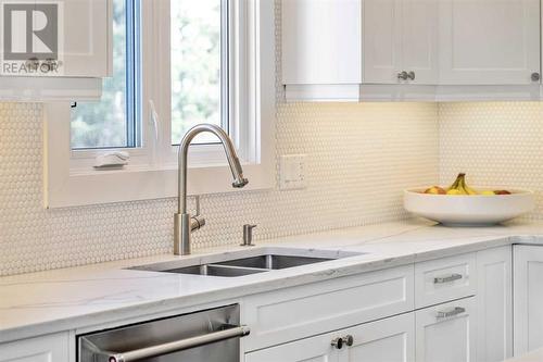 Penny tile backsplash - 432 Strathcona Mews Sw, Calgary, AB - Indoor Photo Showing Kitchen With Double Sink With Upgraded Kitchen