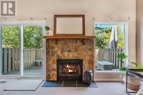 Patio doors lead out to private backyard - 153 Woodglen Grove Sw, Calgary, AB - Indoor With Fireplace