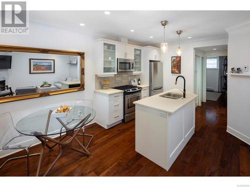 Enter into a bright and open space with high ceilings and quality finishes including walnut floors. - 2 1146 Richardson St, Victoria, BC - Indoor Photo Showing Kitchen With Double Sink With Upgraded Kitchen