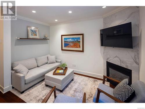 Living room with walnut flooring and a cozy gas fireplace. - 2 1146 Richardson St, Victoria, BC - Indoor Photo Showing Living Room With Fireplace