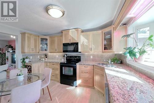 Corner cabinets with glass accent doors - 2417 53 Avenue Sw, Calgary, AB - Indoor Photo Showing Kitchen With Upgraded Kitchen