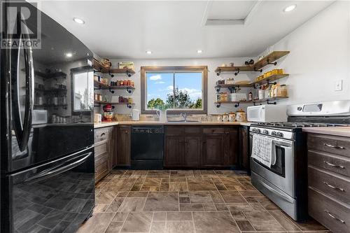 Kitchen offers ample cabinetry and shelving to match the home's interior. Large window overlooks driveway. - 5258 Murphy Road, Calabogie, ON - Indoor Photo Showing Kitchen